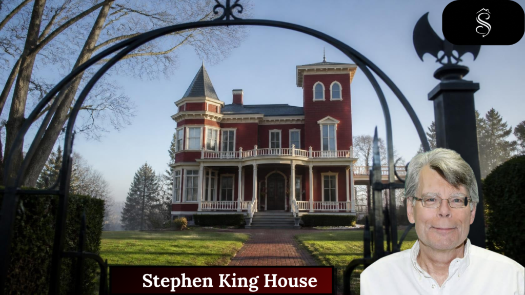Red Victorian Stephen King house in Bangor, Maine, seen through a black iron gate with a bat ornament